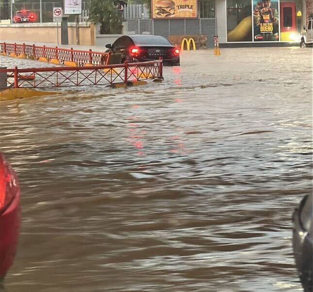 Hombre navega un pequeño velero por calles inundadas en Santiago